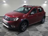 une photo d'une Dacia rouge garée sur un sol à damier