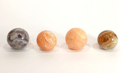 Trois billes de marbre sont alignées sur une surface blanche