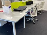 a white table with a laptop on it in an office