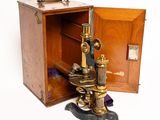 un vieux microscope en laiton rangé dans une boîte en bois