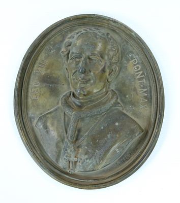une image représentant une médaille de bronze sur laquelle figure un homme vêtu d'une aube