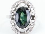 an image of a green tourmaline and diamond ring on a white background