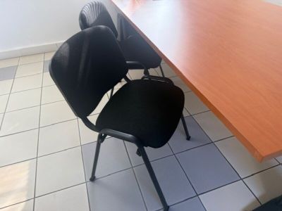 two black chairs and a wooden table in a room