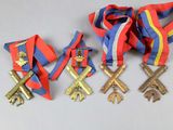 four medals and a ribbon are laying on a white surface