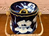 a blue and white flowered ice bucket sitting on a wooden table