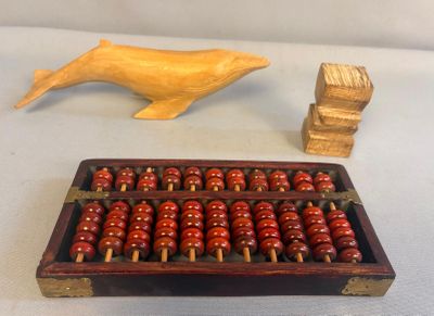 un abaque en bois et une figurine de baleine en bois posés sur une table