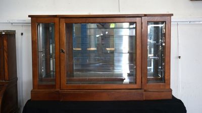 a display case with a glass door on top of a black table