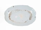 a white plate with brown spots on it on a white surface