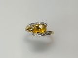 an image of a yellow sapphire and diamond ring on a white surface