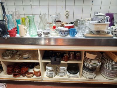de nombreuses assiettes et tasses sur le plan de travail de la cuisine