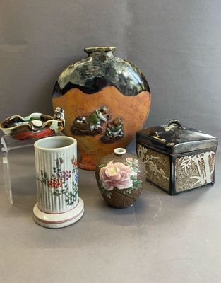 trois vases et une boîte posés sur une table