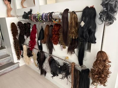 de nombreux types de perruques accrochés au mur