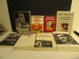 several books are stacked on a table in front of a blackboard