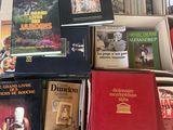 de nombreux livres qui se trouvent dans une boîte posée par terre