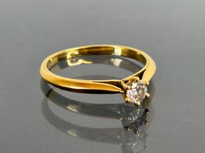a gold ring with a diamond on it on a table