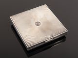a close up of a square silver object on a black surface