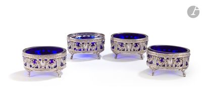 trois bols en verre argenté et bleu posés sur des socles, disposés sur une surface blanche