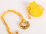 yellow rope with a gold ring and a yellow bag on a white surface