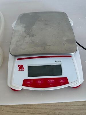 une balance posée sur une table à côté d'un bol de nourriture