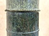 a close up of a green marble vase on a table