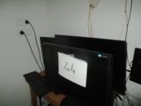 un téléviseur posé sur une table, à côté d'un clavier