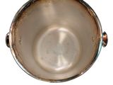 a metal bowl that is sitting on a white surface