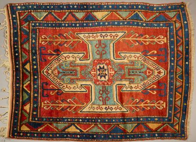 a close up of a red and blue rug with a cross on it