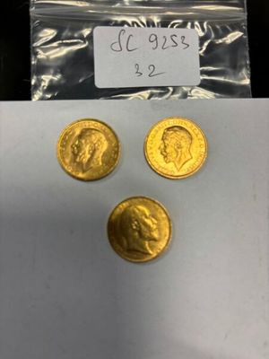 un gros plan sur trois pièces d'or dans un sachet en plastique
