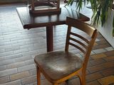 une table en bois sur laquelle se trouvent une chaise et une plante en pot
