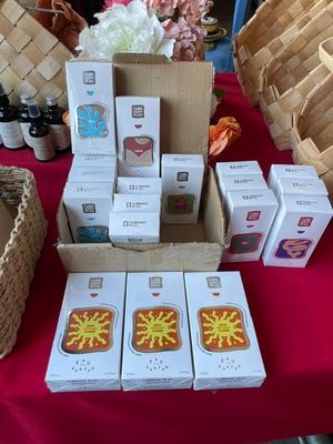 many boxes of cookies on a table with baskets of flowers