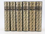 un lot de cinq livres posés sur une surface blanche