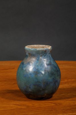 a small blue vase sitting on a wooden table