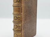 an old book sitting on top of a white surface