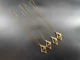 un ensemble de quatre colliers en or posés sur un fond noir