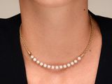 La femme porte un collier orné de perles.