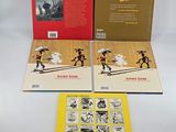 three books on a white table with yellow covers and red covers