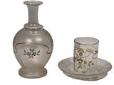 un vase en verre et un verre posés sur une assiette