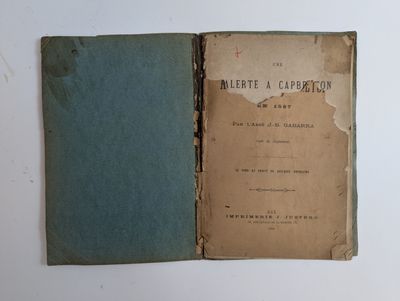 un vieux livre à la couverture bleue posé sur une table blanche