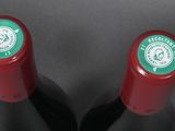 two bottles of red wine sitting on top of a table
