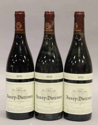 trois bouteilles de vin posées sur une table l'une à côté de l'autre
