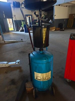 un réservoir bleu posé sur un chariot dans un garage