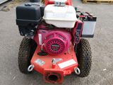 a red lawn mower with a small engine on it