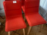 three red chairs with a price tag on them sitting on a wooden floor