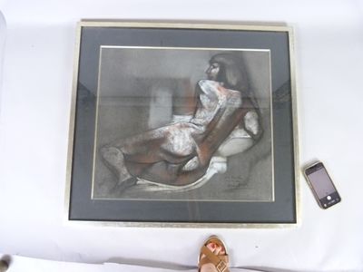 une photo d'une femme assise sur une chaise à côté d'un téléphone portable