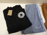 three pairs of men ' s nike shorts and a t - shirt on a table