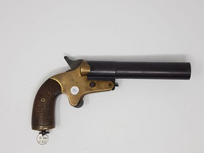 un vieux revolver avec une poignée en bois sur une surface blanche