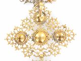 a gold cross on a white background with a chain around it