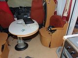 an image of a small camper with a table and chairs