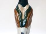 a figurine of a man sitting on top of a white base