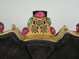 a black purse with a gold frame and a pink and green bead